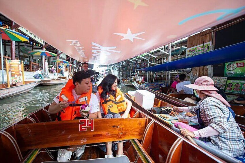 A boat with people on it, a person in an orange life jacket, and a person in a hat. 2