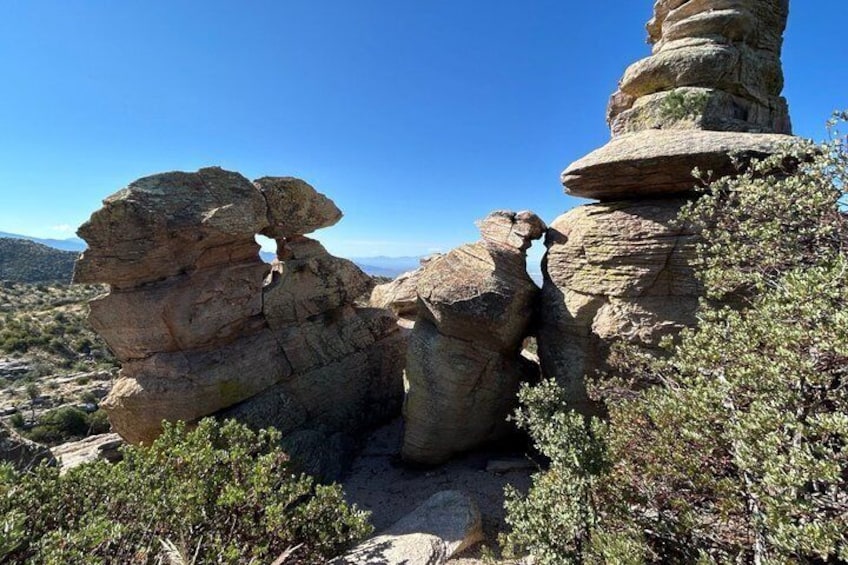 A rocky landscape with layered rock formations and sparse vegetation. 5