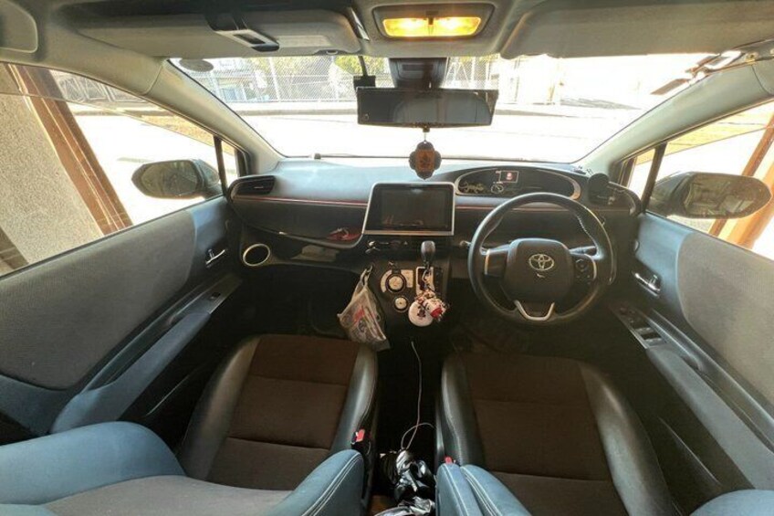 A car's interior with a steering wheel, dashboard, and center console. 3