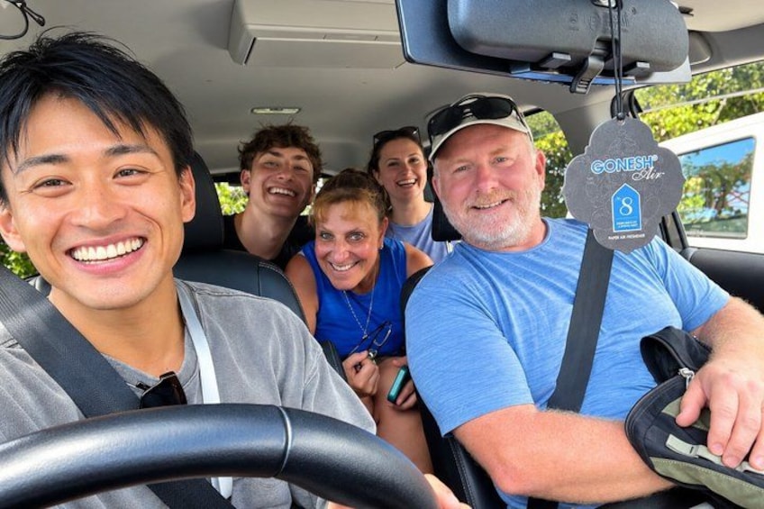 A group of people inside a vehicle with a GoNesh Shop sign. 5