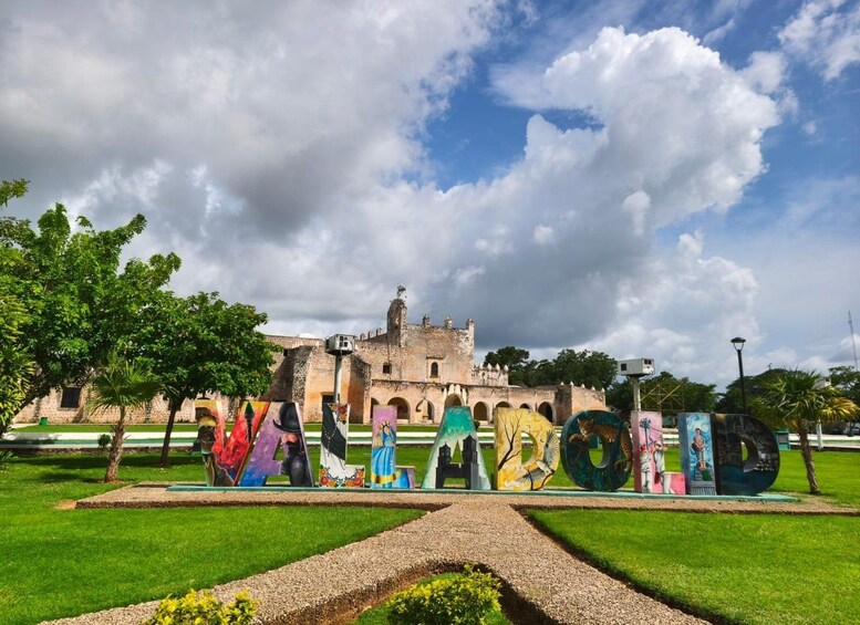 A historic building with murals, a clear sky, and a well-maintained lawn. 2