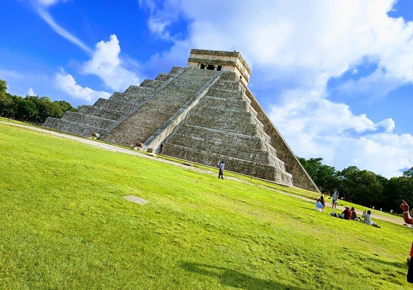 A large pyramid structure with a grassy foreground and a clear blue sky. 1