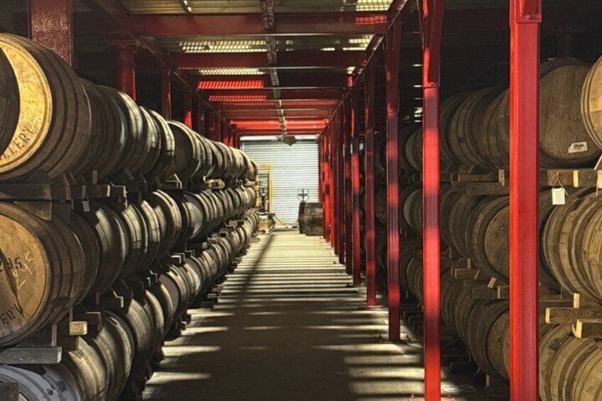 A warehouse with rows of wooden barrels. 5