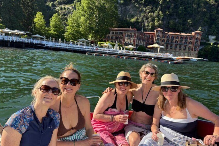 A group of people on a boat with a building and trees in the background. 5