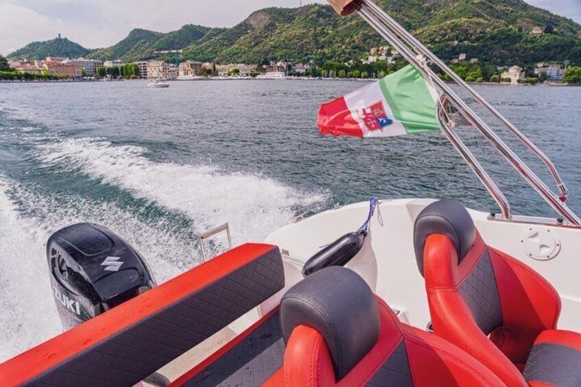 A boat with red and black seats, a steering wheel, and a flag. 2