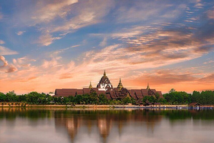 A temple complex with a reflection in the water, surrounded by trees and a clear sky. 4