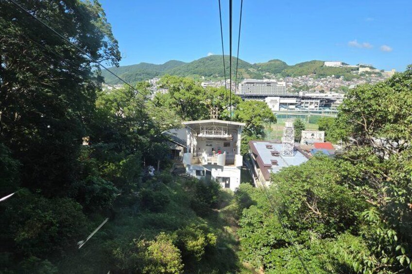 A house surrounded by dense greenery, a bridge in the background, and a mountainous landscape. 2