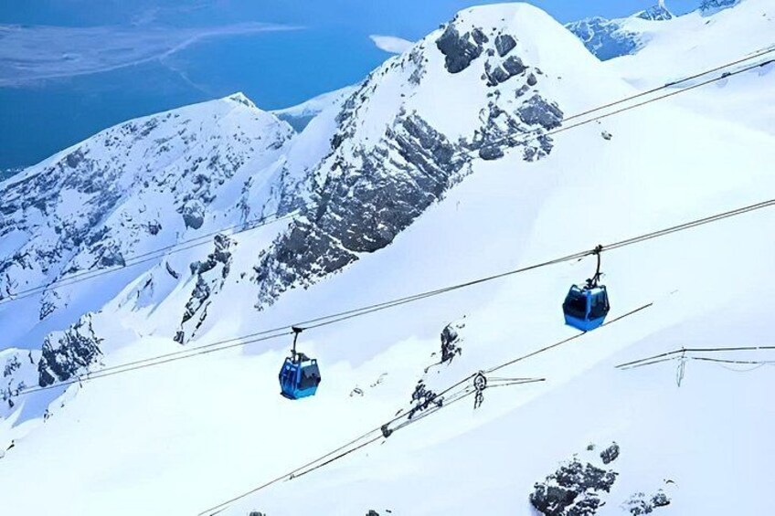 A snowy mountain landscape with ski lifts and cables. 3