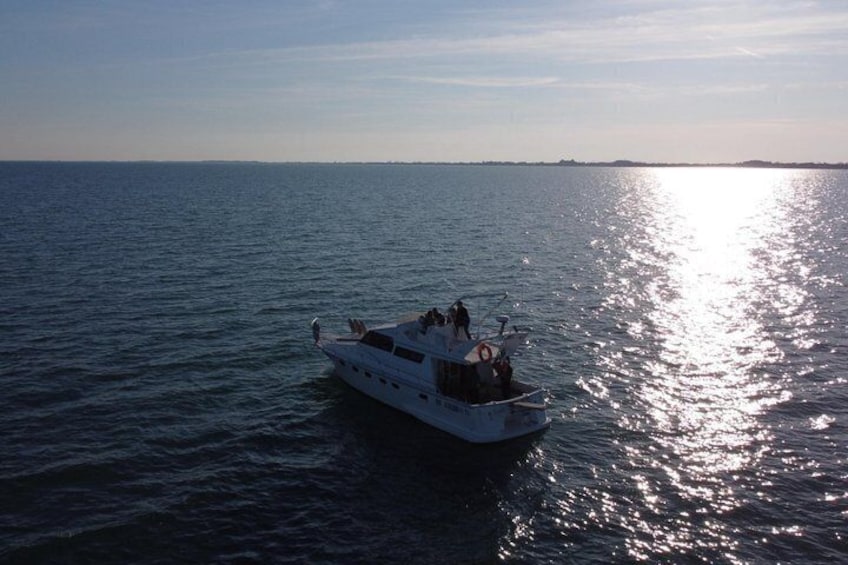 A white boat on calm water with a clear horizon. 2