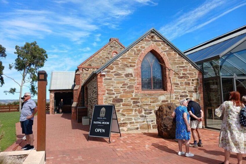 A stone building with a sign indicating a tasting room is open. 5