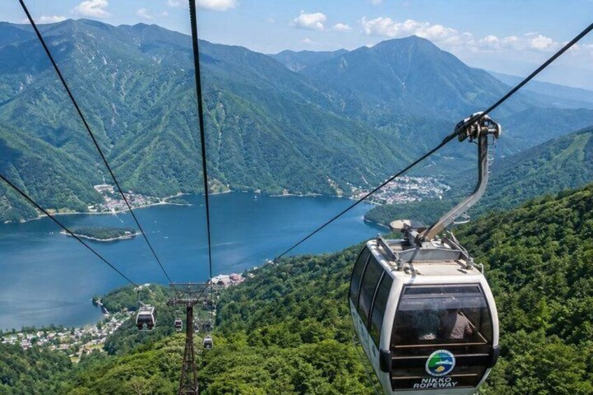 A cable car with a scenic view of a lake and mountains. 3