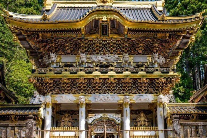 A traditional Japanese temple with ornate golden decorations and multiple statues. 1