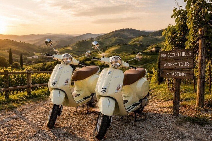 Two vintage scooters parked on a gravel path with a sign for Prosecco Hills Winery Tour & Tasting. 3