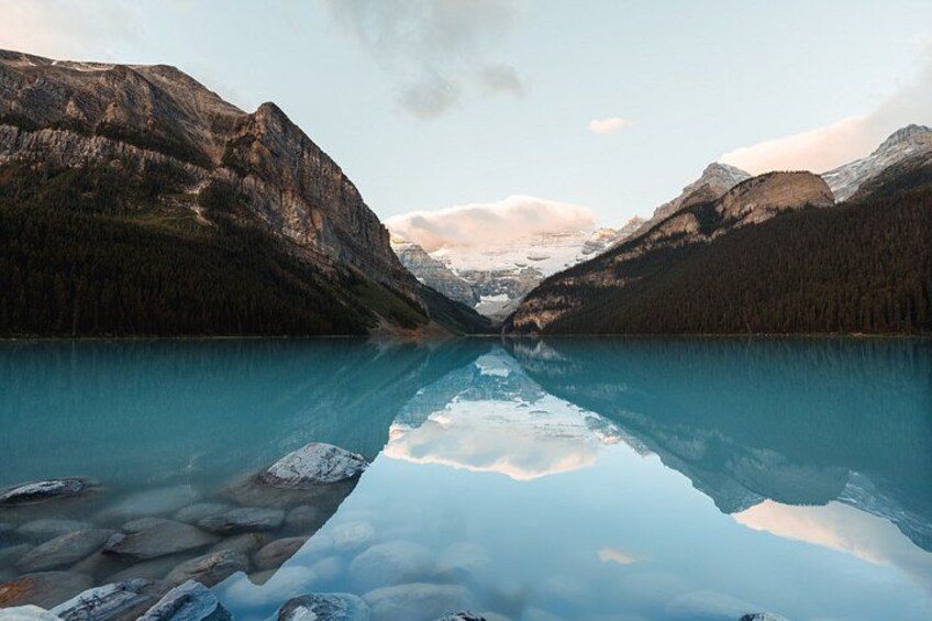 A mountain lake with clear reflections, surrounded by forested mountains. 2