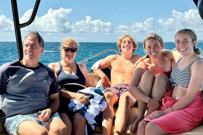A group of people on a boat with the ocean and sky in the background. 5