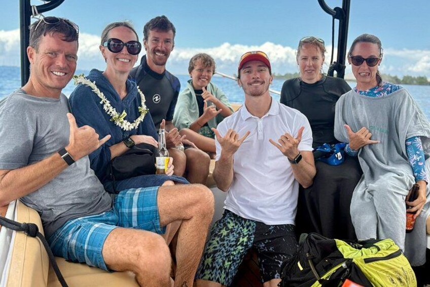 A group of people on a boat with a clear sky and calm sea. 4