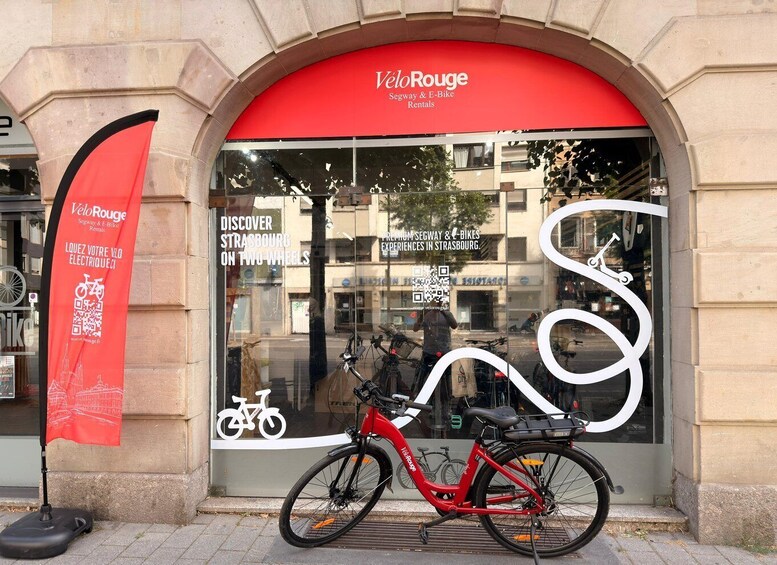A storefront with a red awning and a bicycle parked outside. 3