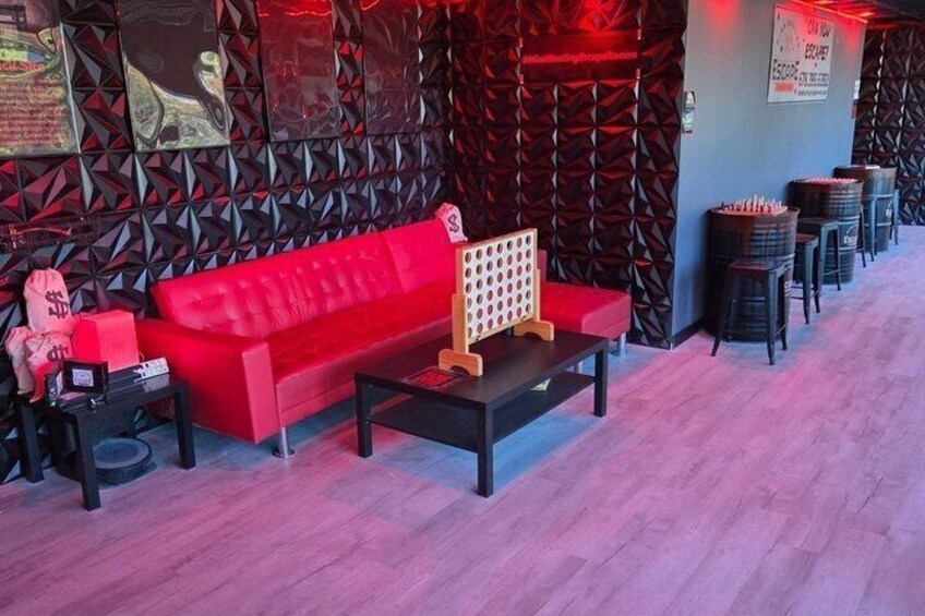 A red sofa, black coffee table, and patterned wall in a room. 3