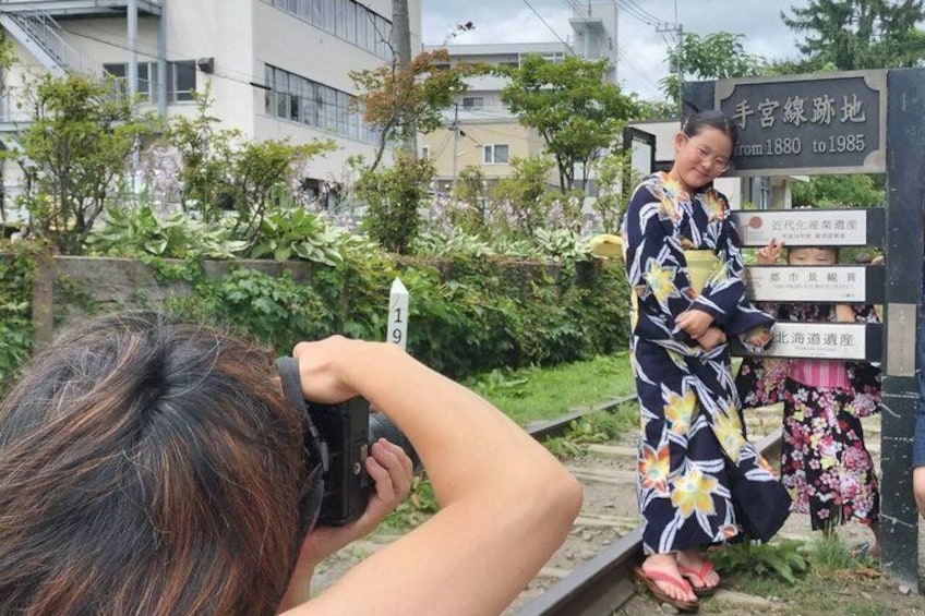 A person taking a photo of a sign with Japanese characters, a number 19, and a person in traditional attire. 2