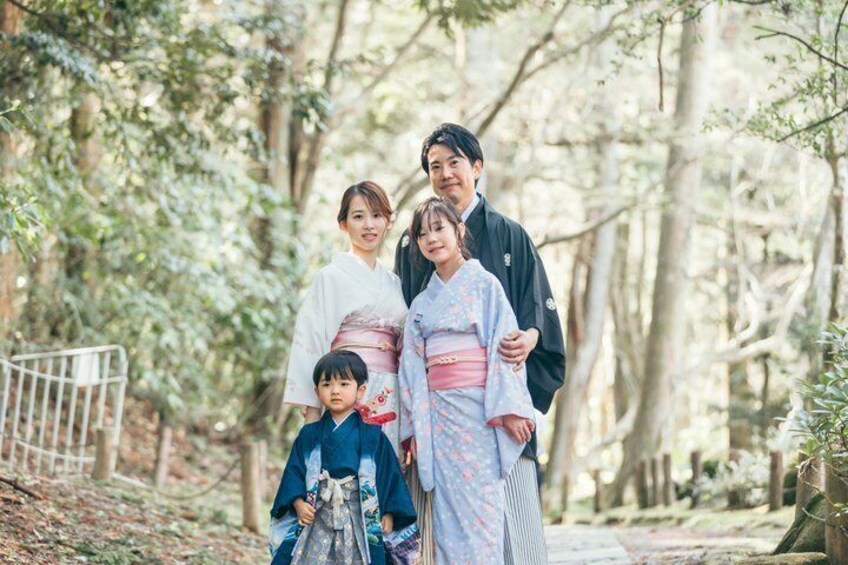 A family in traditional Japanese attire in a forested area. 4