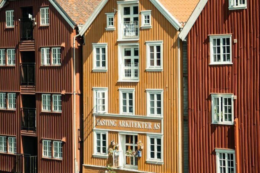 A building with a sign that reads 'Fasting Arkitekter AS' and a red facade. 3