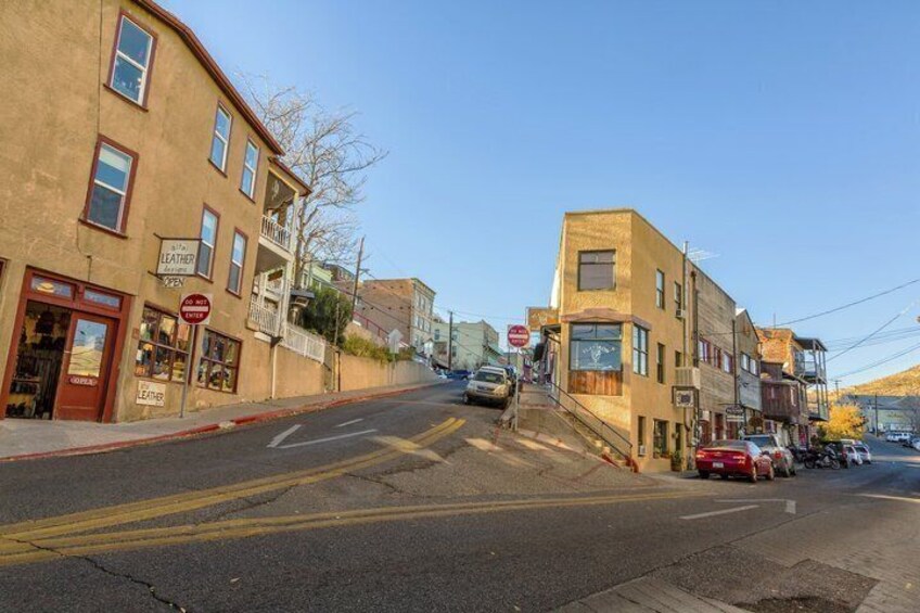 A street with buildings, a stop sign, and cars. 3