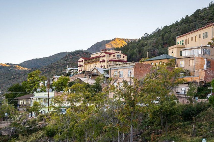 A hillside town with buildings, trees, and a mountain in the background. 3