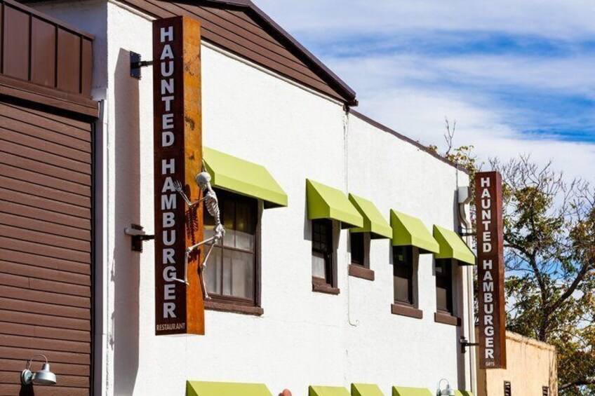 A building with a sign reading 'Haunted Hamburger Restaurant' and a skeleton figure. 4