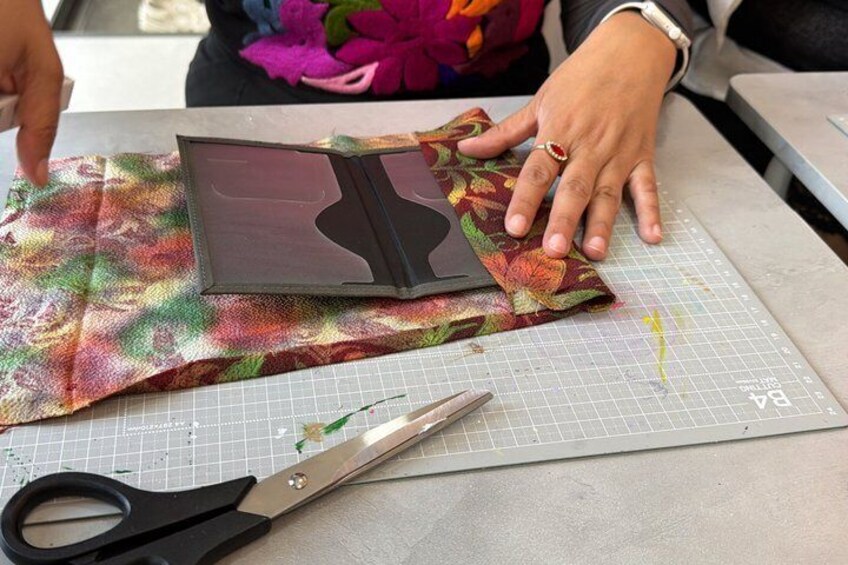 A person cutting fabric on a cutting mat with scissors and a template. 4