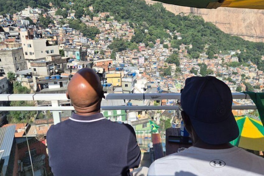 Two people overlooking a densely populated urban area with buildings and greenery. 5