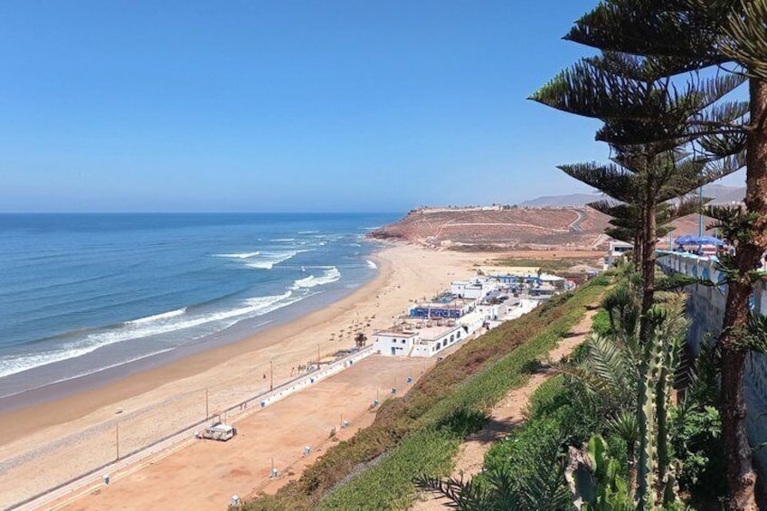 A coastal landscape with a beach, a road, and a row of buildings. 2