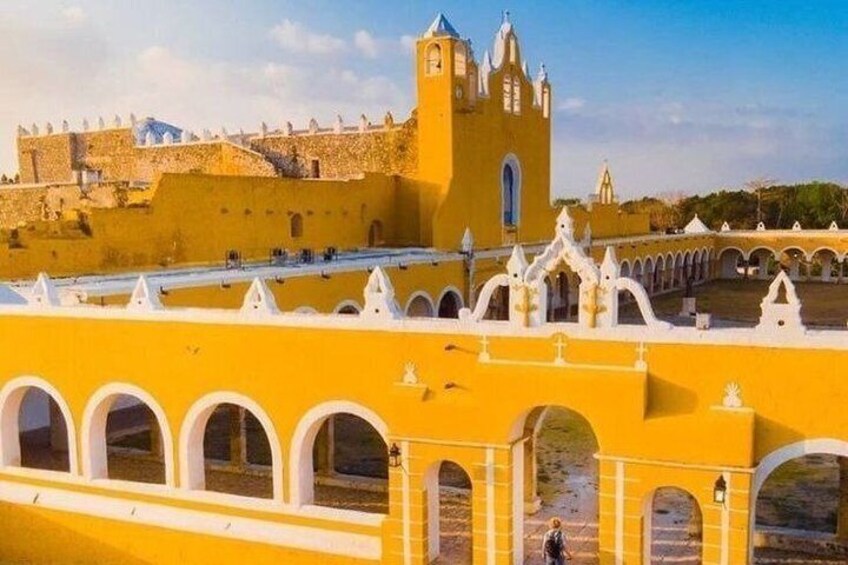 A yellow building with arches and a tower. 2