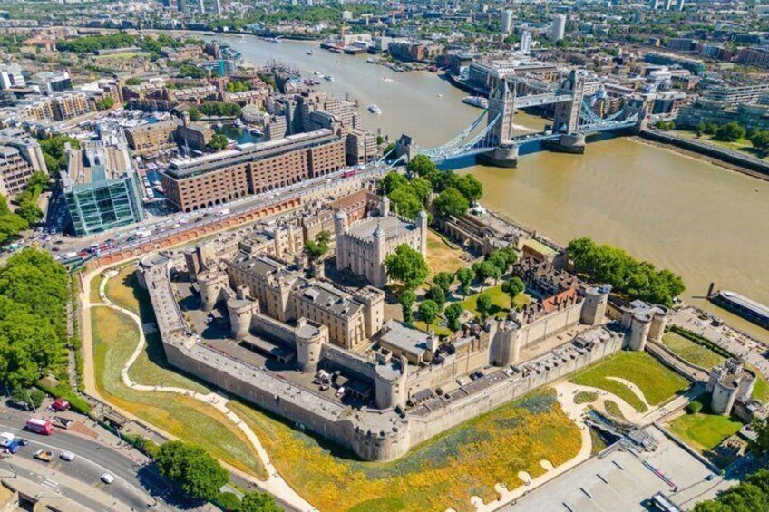 A historic castle surrounded by a moat, with a river and a bridge in the background. 3