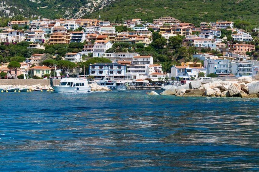 A coastal town with buildings, boats, and rocky shoreline. 5