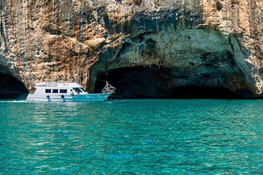 A boat near a rocky cave entrance. 3
