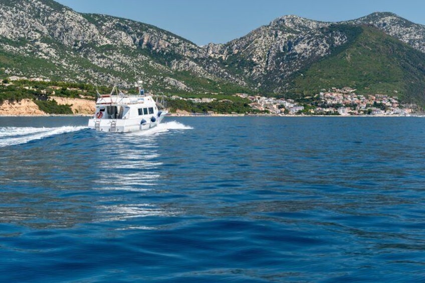 A boat on a calm sea with mountains in the background. 3