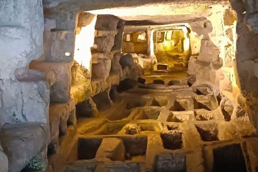 An ancient cave with stone walls and a central passageway. 4