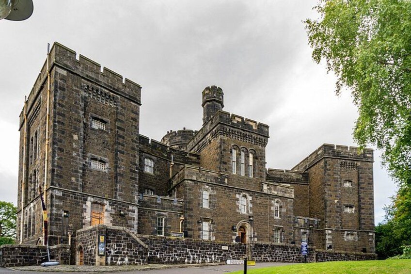 A large, historic stone building with multiple towers and arched windows. 3