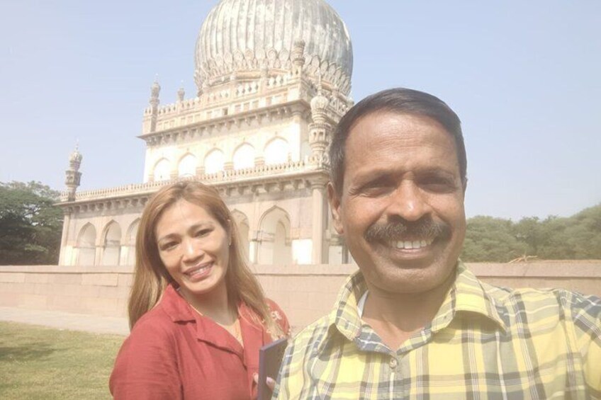 Two people standing in front of a large domed building with arches. 2
