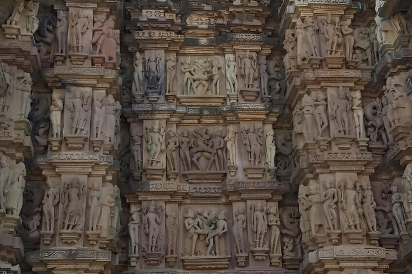 A detailed stone wall with intricate carvings of figures and scenes. 4