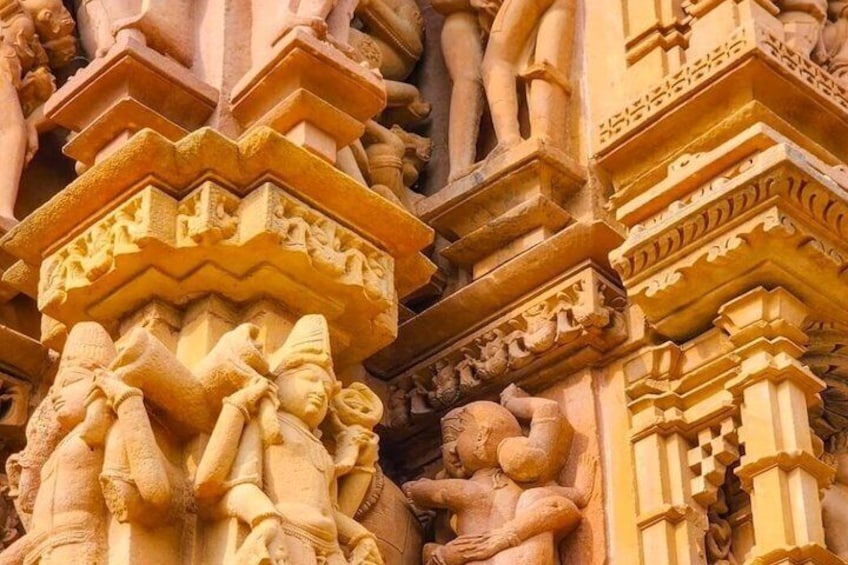 Detailed stone carvings on a temple facade, featuring multiple figures and intricate patterns. 2