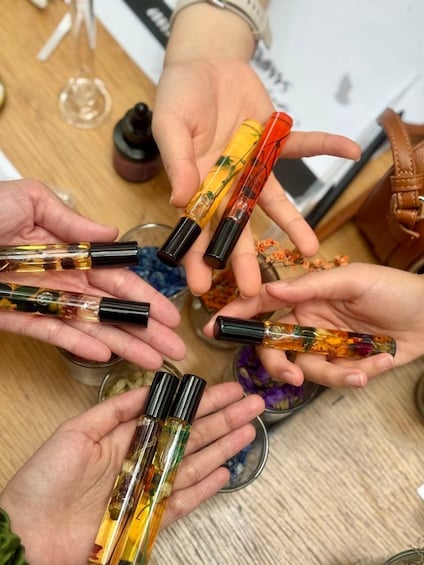 A group of people holding pens with colorful, translucent bodies. 5