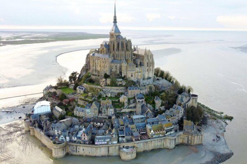 A coastal town with a prominent cathedral, a fortified wall, and a beach. 2