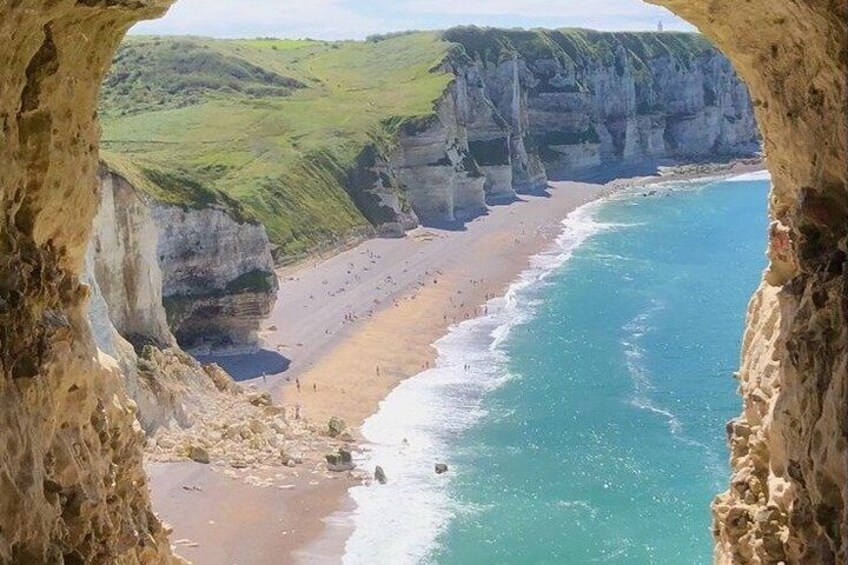 A coastal landscape with cliffs, a beach, and a clear blue sea. 5