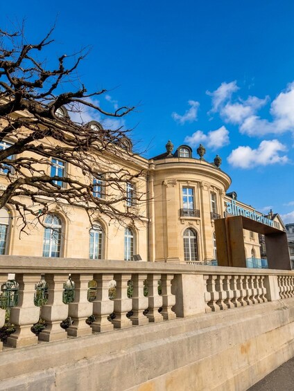 A classical building with a curved facade, large windows, and a balcony. 4