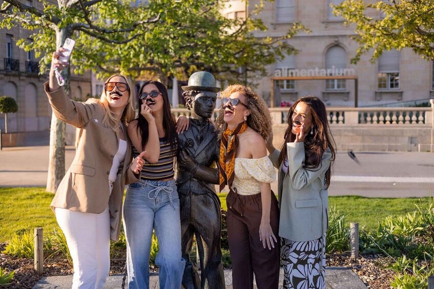 A group of people taking a selfie with a statue in the background. 2