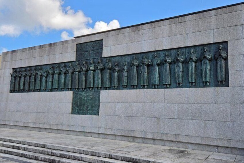 A stone wall with a relief sculpture of figures. 5