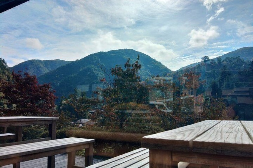 A wooden deck overlooking a mountainous landscape with trees and buildings. 3
