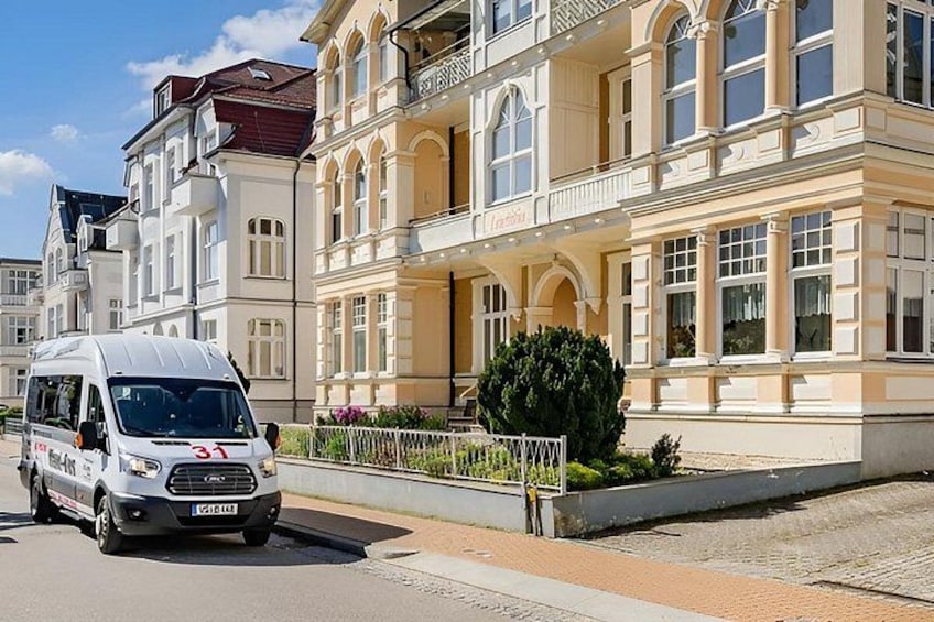 A white van with the number 31 parked in front of a large, ornate building with multiple windows and balconies. 1