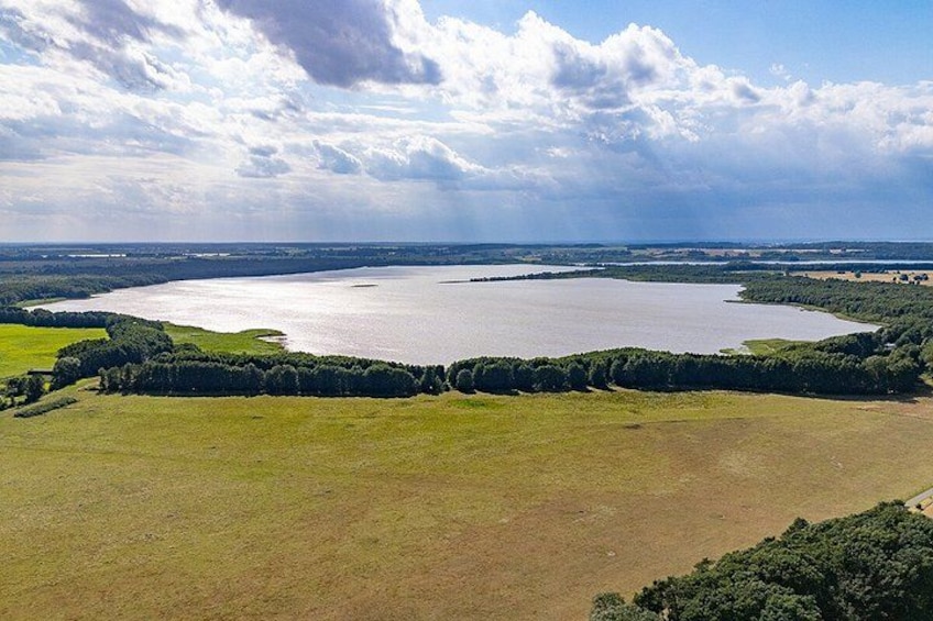 A large lake surrounded by green fields and trees. 5